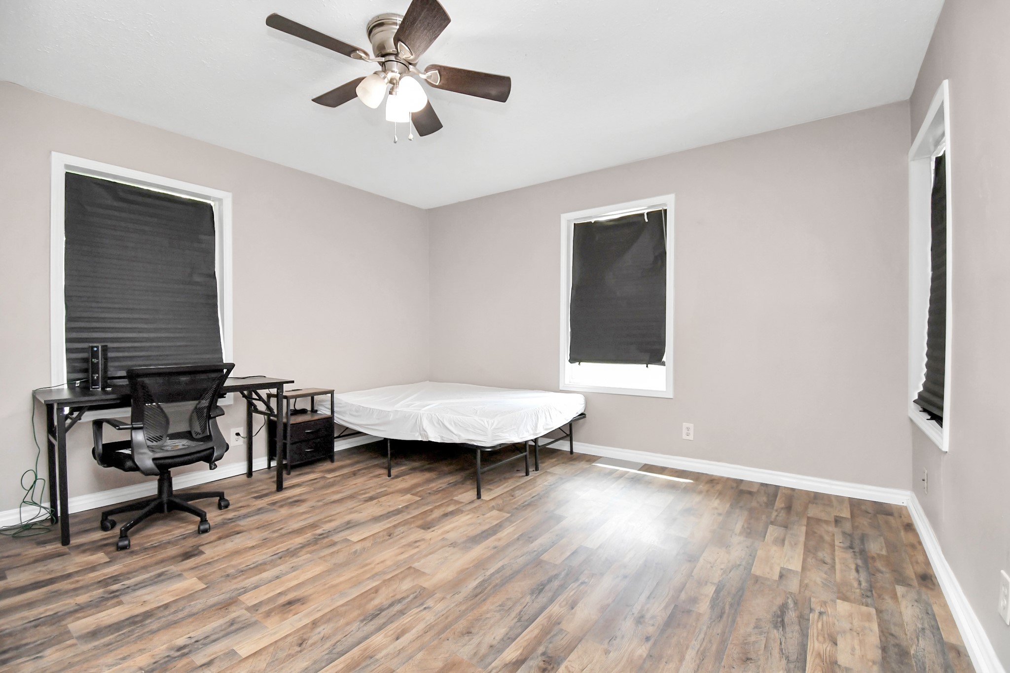 3743 Odin Court Houston, TX 77021 - Photo 19 of 36 Continuous comfort and smart design. Mirroring the bright aesthetic of the previous room, this bedroom features a storage closet, a cooling fan, and enough space to incorporate a workspace.