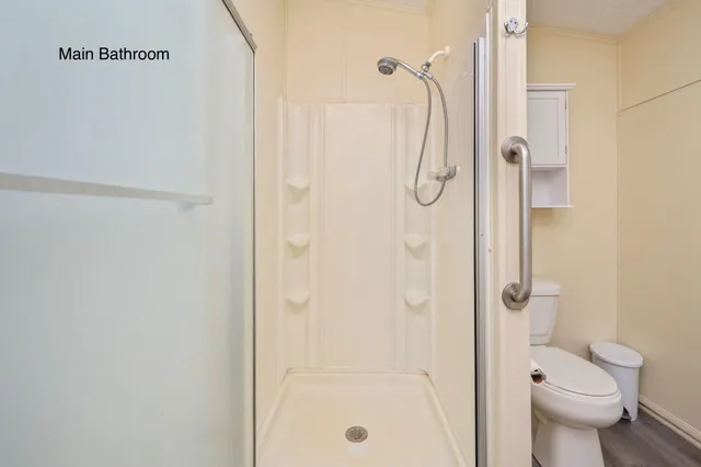 a bathroom with a granite countertop shower a toilet and a shower