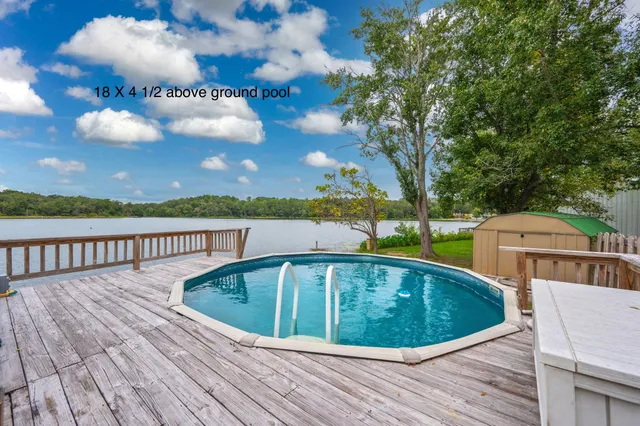 a view of a swimming pool with deck and outdoor seating