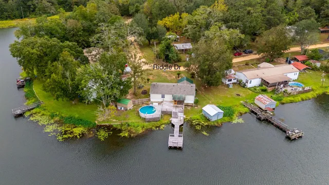 an aerial view of a house with swimming pool and outdoor seating