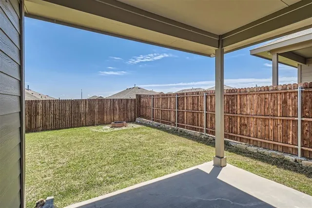 a view of a backyard with wooden fence