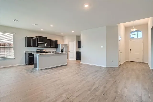 a view of kitchen with microwave oven stove and cabinets