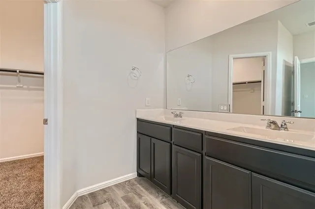 a bathroom with a double vanity sink and a mirror