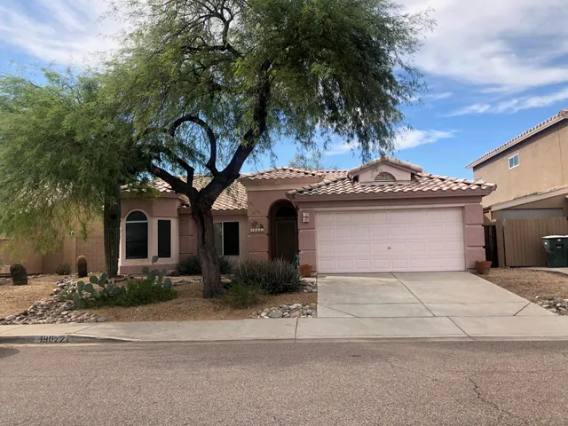 a front view of a house with yard and parking