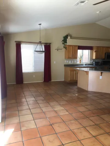 a kitchen with granite countertop a rug a stove a microwave and a counter top space