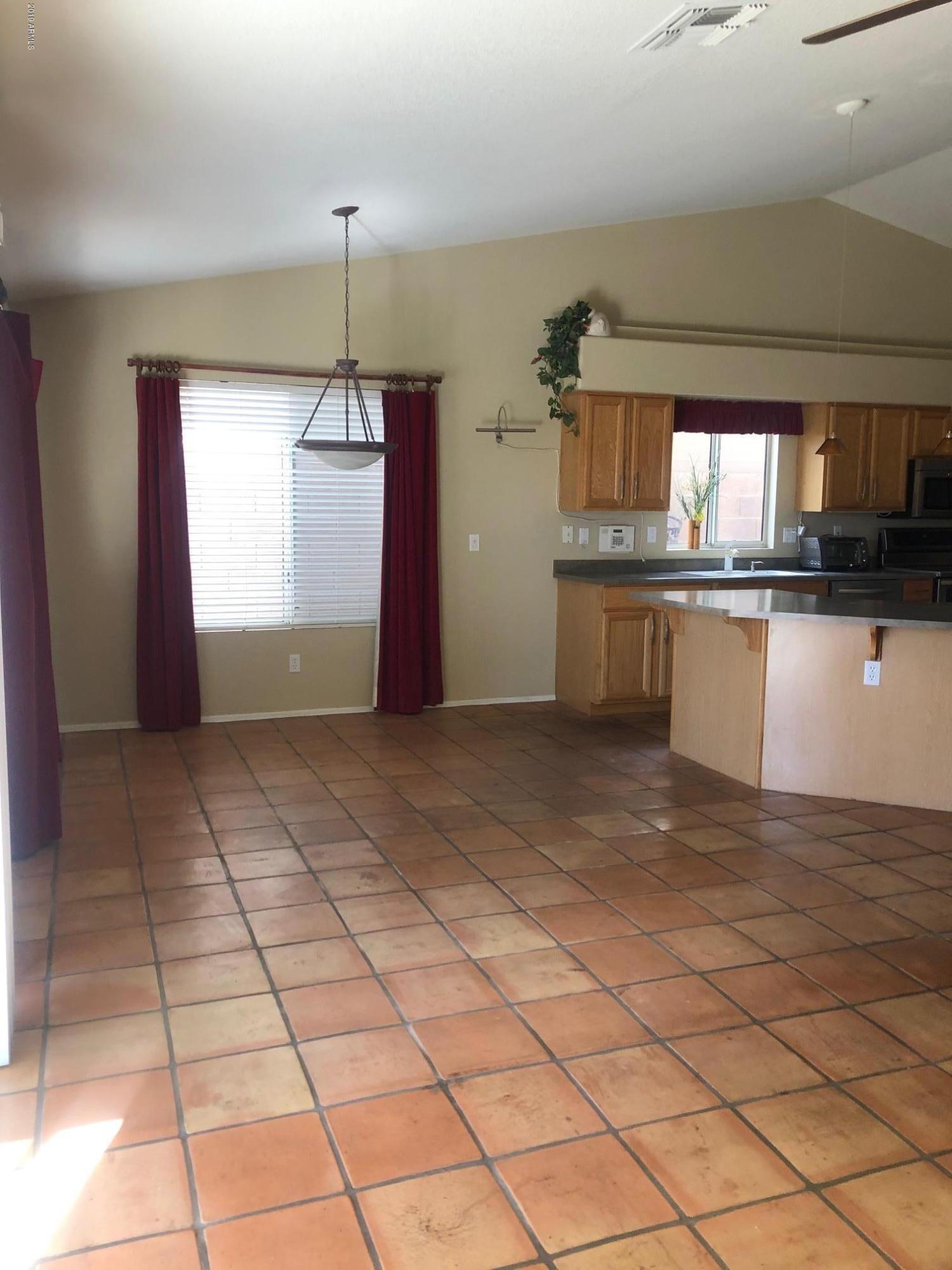 19022 North 24th Place Phoenix, AZ 85050 - Photo 6 of 20 a kitchen with granite countertop a rug a stove a microwave and a counter top space