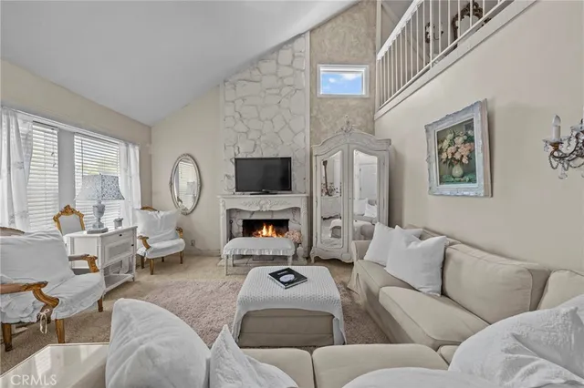 a living room with furniture a fireplace and a large window
