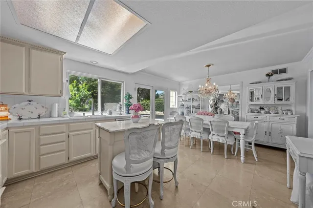 a kitchen with a dining table chairs and large window