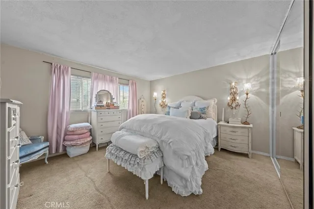 a spacious bedroom with a bed and a lamp