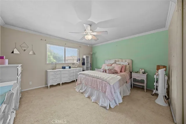 a bedroom with a bed and a chandelier fan