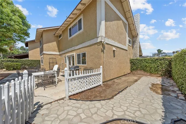 a view of a white house with a yard and table and chairs