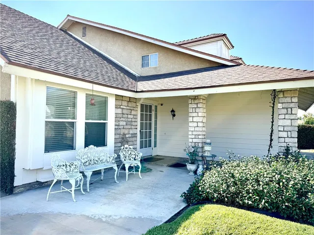 a backyard of a house with table and chairs