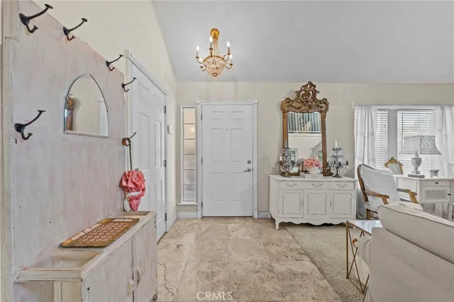 a view of hall way with furniture and chandelier