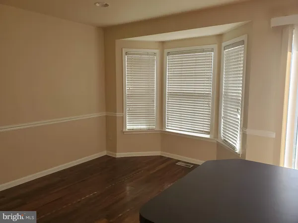 a view of a room with wooden floor and a window