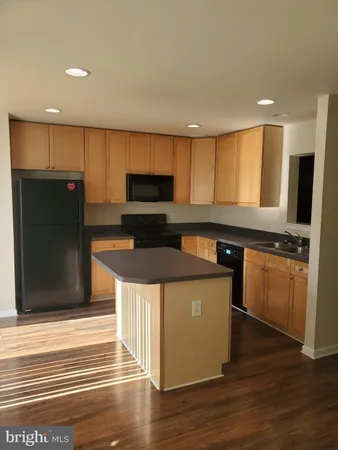 a kitchen with stainless steel appliances kitchen island granite countertop a stove a refrigerator and a microwave