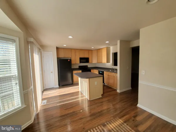 a kitchen with a refrigerator and a stove top oven