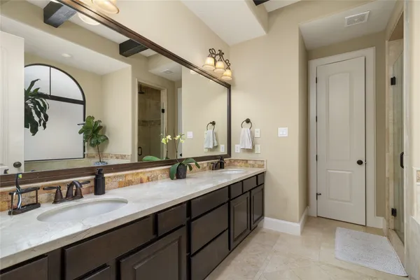a spacious bathroom with a double vanity sink and a mirror