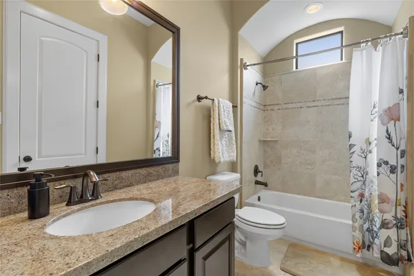 a bathroom with a granite countertop sink toilet and shower