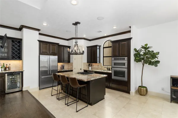 a kitchen with stainless steel appliances granite countertop a sink a stove and refrigerator