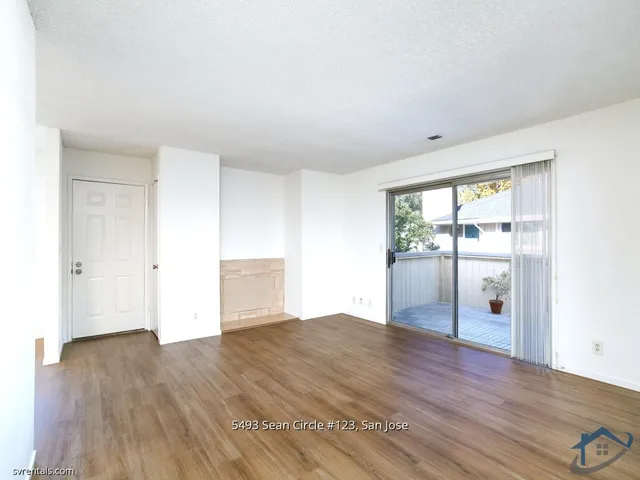 an empty room with wooden floor and sliding door
