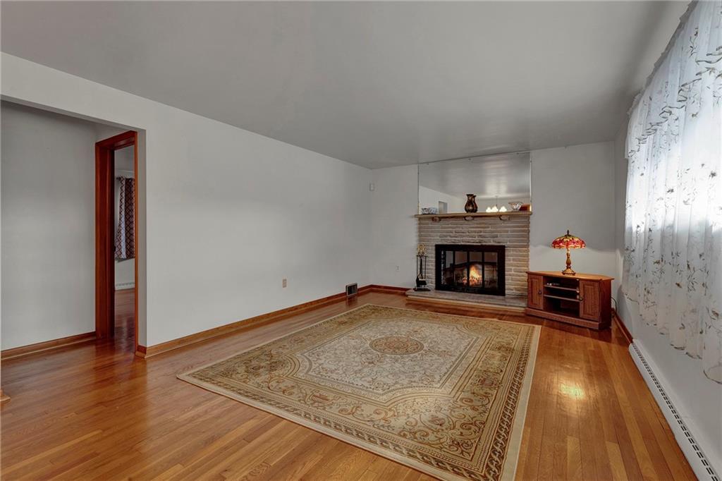 1256 Blaine Road Monaca, PA 15061 - Photo 7 of 23 Focal point in the living room is a stone wood burning fireplace, large picture window with a lot of natural sunlight. Fireplace could be easily changed to gas.