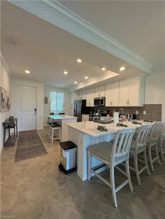a large white kitchen with lots of counter space dining table and chairs