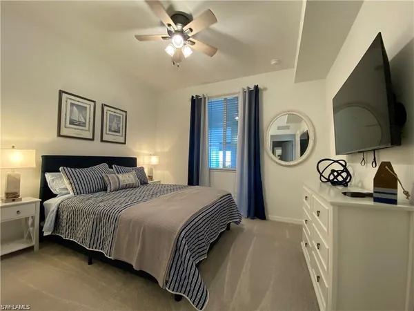 a bedroom with a bed and a flat tv screen on the dresser