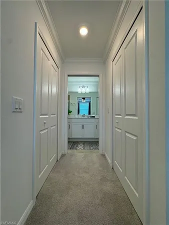 a view of a hallway with closet and wooden door