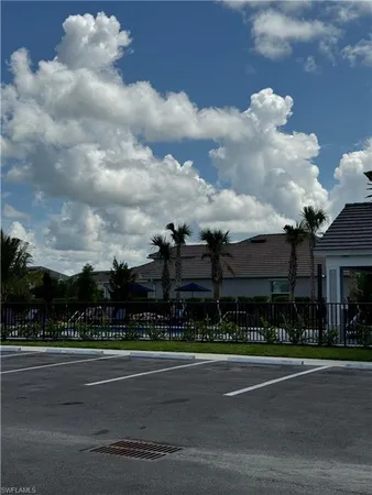 a view of a sign in front of a house with a big yard and large trees