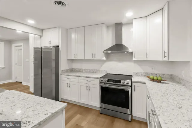 a view of kitchen with kitchen island wooden floor center island and stainless steel appliances