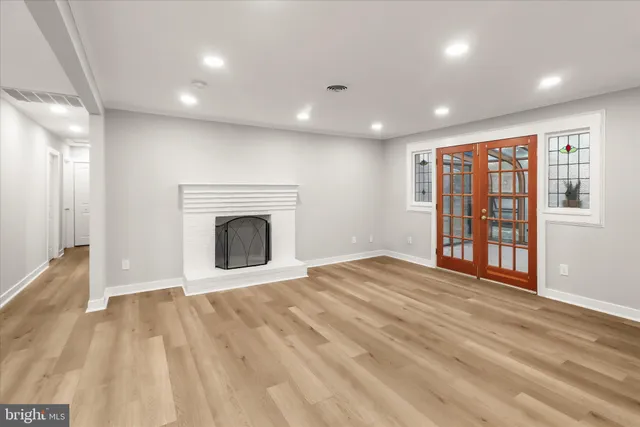 a view of an empty room with a fireplace and a window