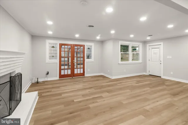 a view of an empty room with a window and a kitchen
