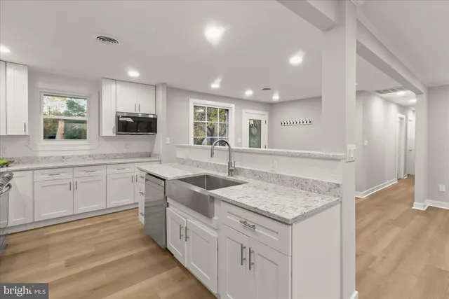 a view of an empty room with furniture and a window