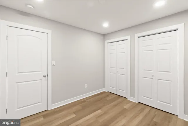 a view of a hallway with wooden floor and closet