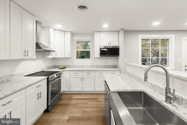 a kitchen with granite countertop a sink stainless steel appliances and cabinets
