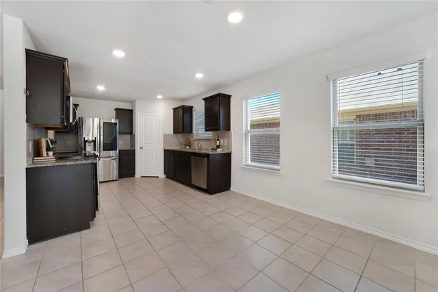a large kitchen with kitchen island granite countertop a refrigerator and a sink