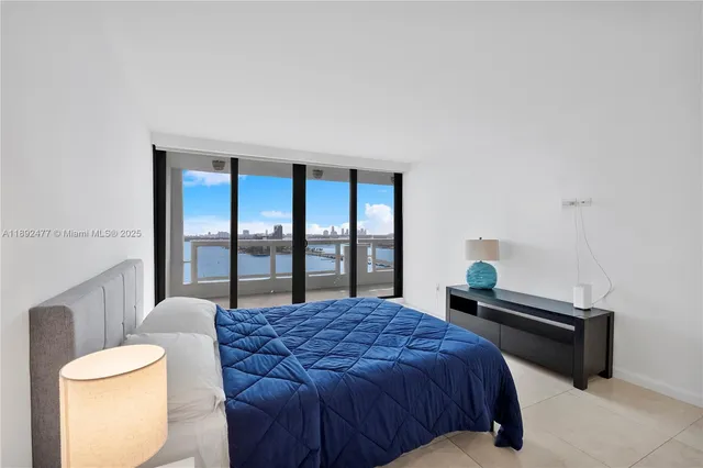 a bedroom with a bed and a large window