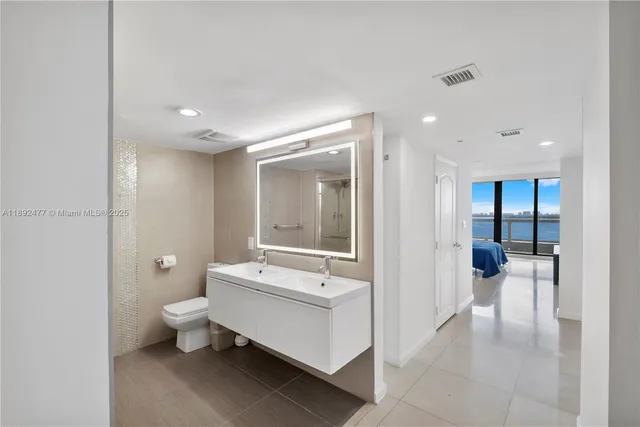 a bathroom with a double vanity sink toilet and shower
