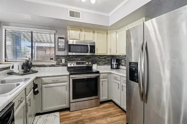 a kitchen with stainless steel appliances a stove sink and refrigerator