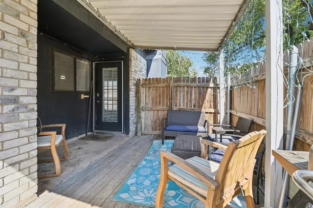 a view of a patio with table and chairs with wooden floor and fence