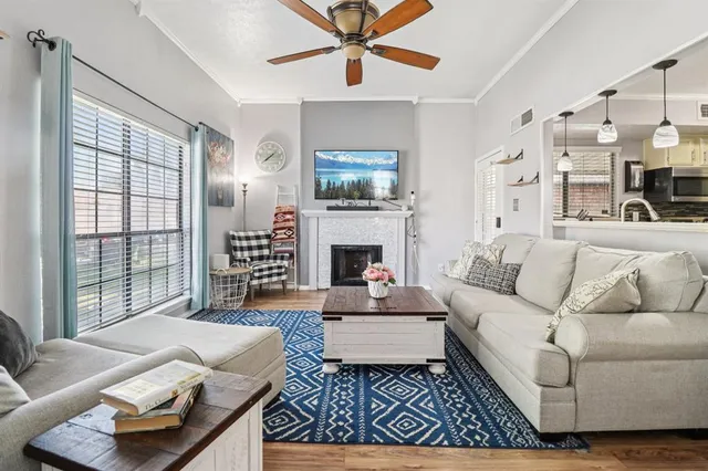 a living room with furniture a flat screen tv and a fireplace