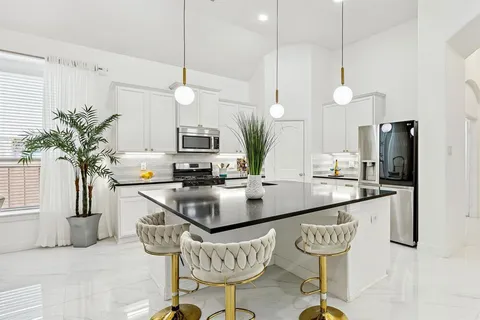 a kitchen with stainless steel appliances granite countertop a kitchen island a stove a table and chairs