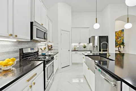a kitchen with stainless steel appliances granite countertop a kitchen island a stove a table and chairs