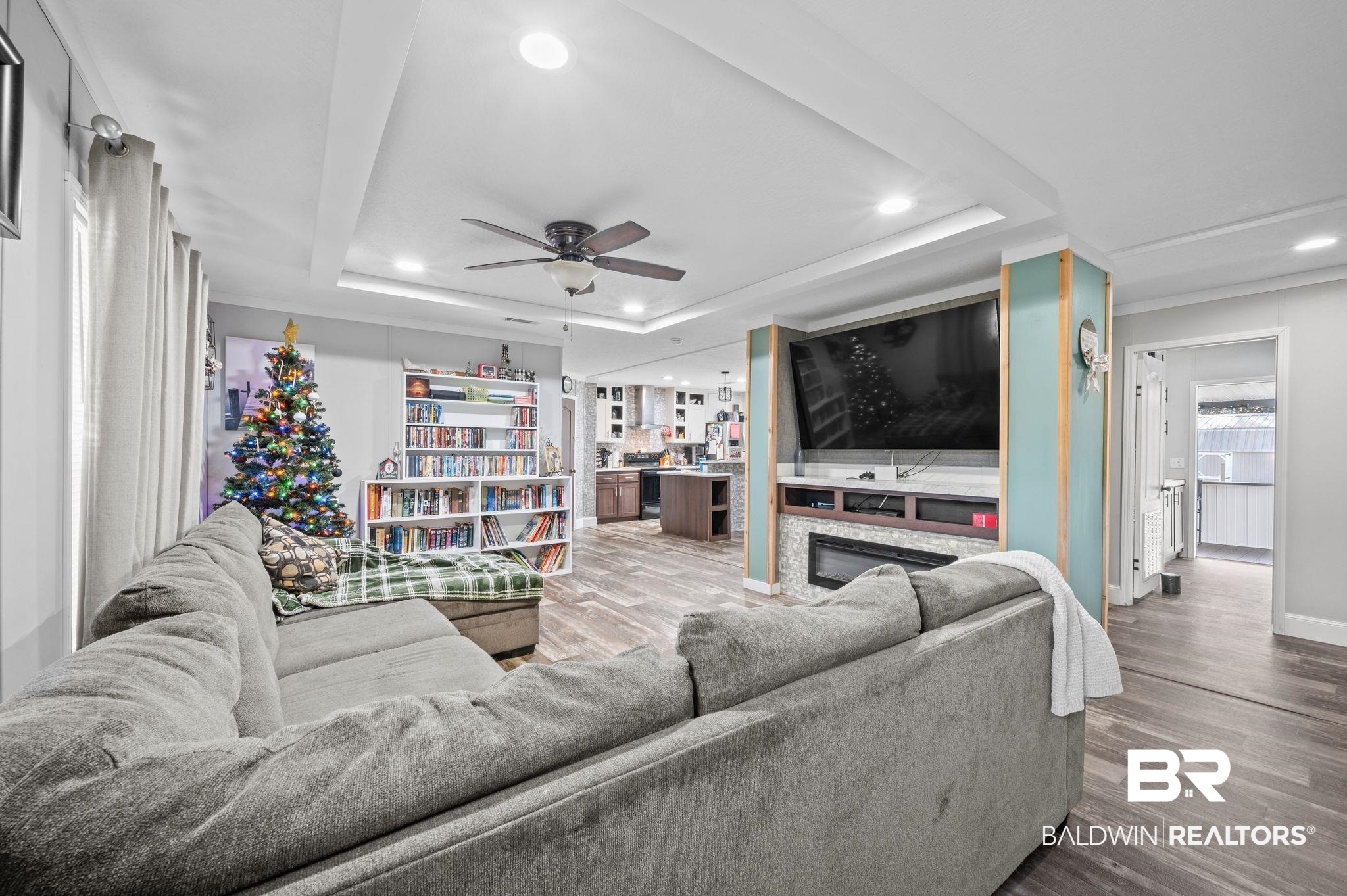 9382 D'Olive Street Bay Minette, AL 36507 - Photo 3 of 27 Living room featuring a tray ceiling, hardwood / wood-style flooring, and ceiling fan