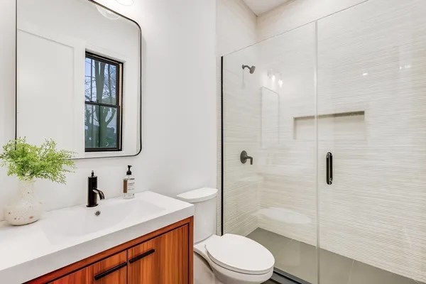 a bathroom with a sink toilet vanity and shower