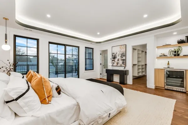 a bed sitting in a spacious bedroom next to a window