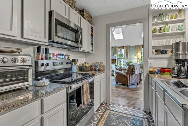 a kitchen with stainless steel appliances granite countertop a stove and cabinets