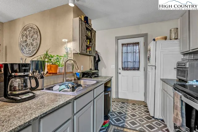 a kitchen with sink a stove and a clock