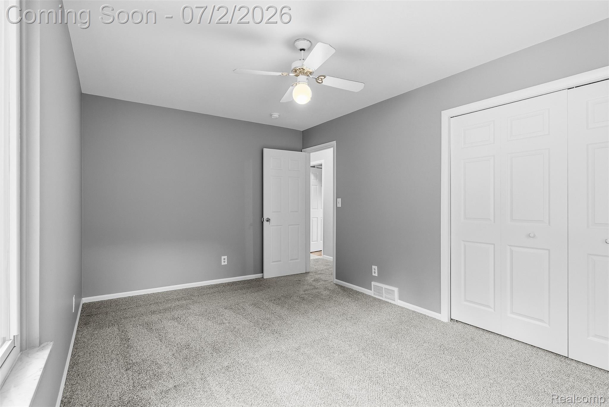 305 East Road Holly, MI 48442 - Photo 19 of 41 Carpeted interior space featuring a ceiling fan with integrated lighting, a white painted door, and white bi-fold closet doors