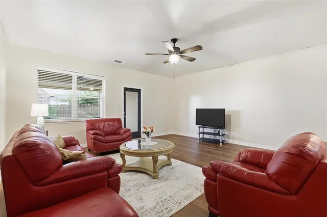 a living room with furniture ceiling fan and a window